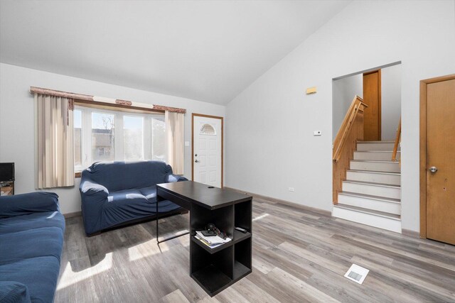 296 E Crest Ave, Bensenville, IL 60106 - living room featuring lofted ceiling, light wood-type flooring, stairway, and baseboards