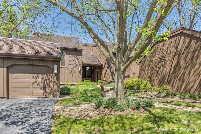 mid-century inspired home featuring an attached garage and driveway