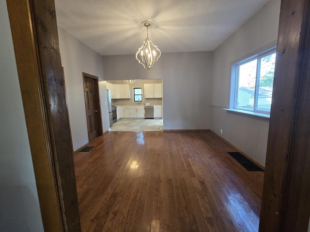 310 N Mulberry St, Clinton, IL 61727 - unfurnished dining area featuring wood finished floors and a chandelier