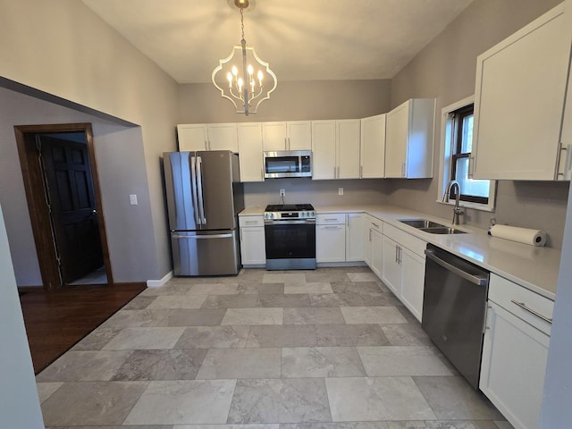 310 N Mulberry St, Clinton, IL 61727 - kitchen with stainless steel appliances, a sink, a chandelier, white cabinets, and light countertops