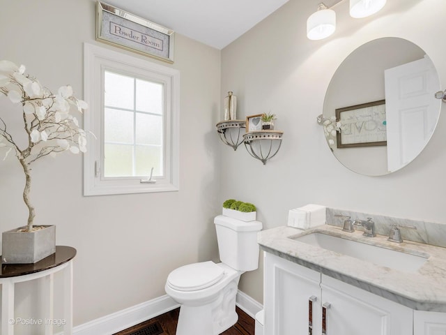bathroom with baseboards, toilet, vanity, and wood finished floors