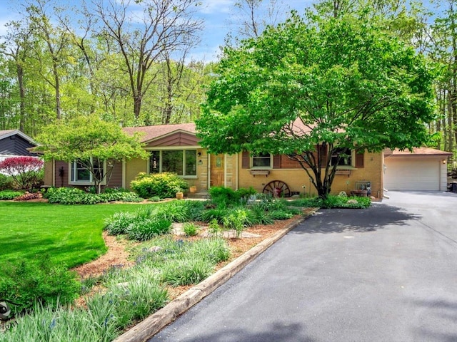 view of front of property featuring driveway, a front yard, and a garage