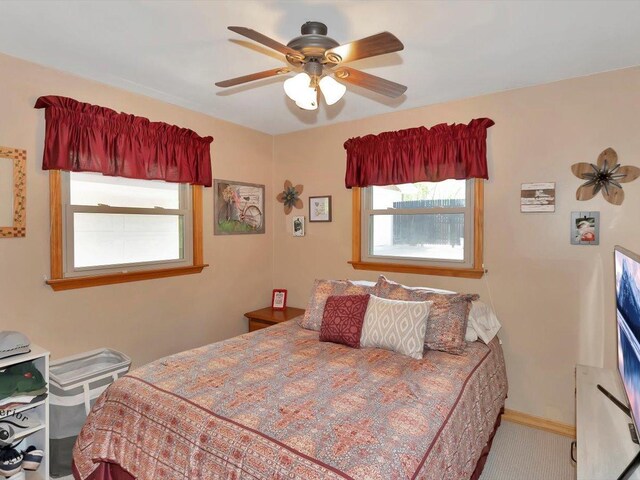 bedroom with carpet floors, a ceiling fan, and baseboards