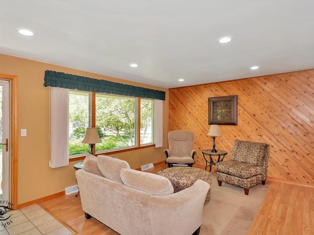 living area with baseboards, recessed lighting, an accent wall, and light wood-style flooring
