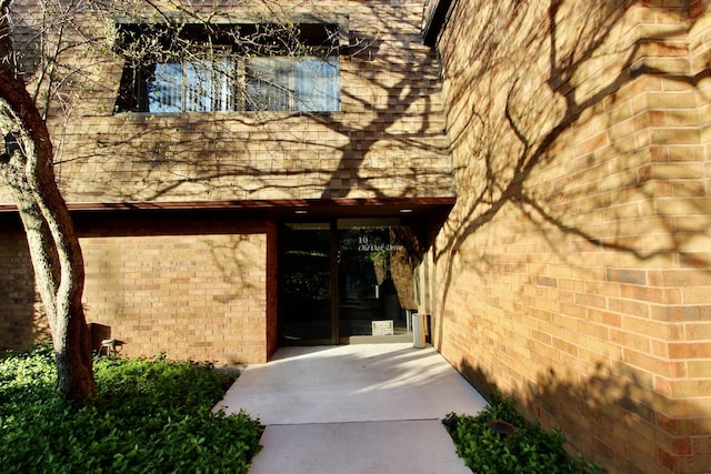 doorway to property featuring brick siding