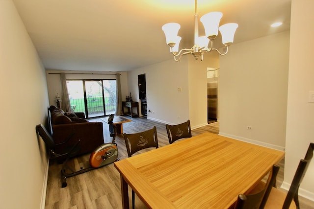dining area featuring wood finished floors, a chandelier, and baseboards