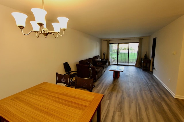 dining area with dark wood finished floors, a chandelier, and baseboards