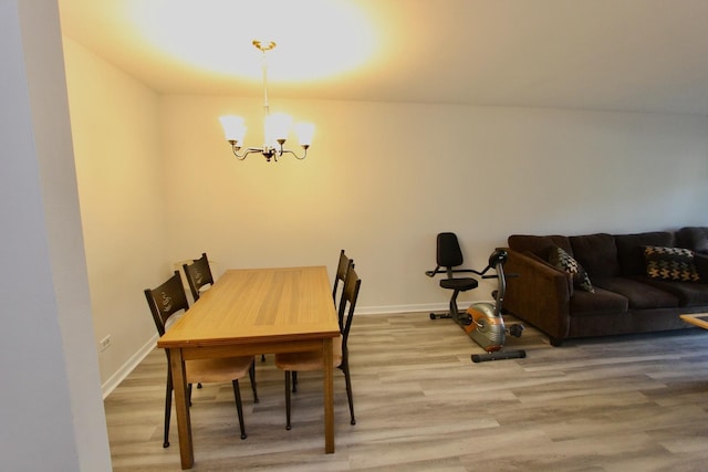 dining room featuring a chandelier, light wood finished floors, and baseboards