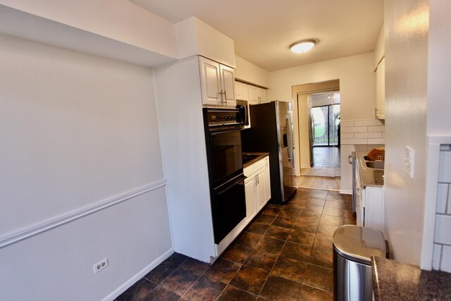 kitchen with stainless steel fridge, tasteful backsplash, white cabinets, and baseboards