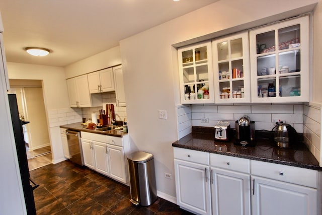 kitchen featuring stainless steel dishwasher, white cabinetry, backsplash, glass insert cabinets, and baseboards