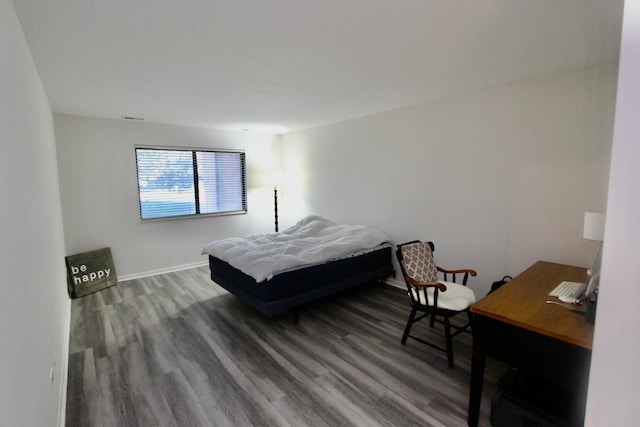 bedroom with wood finished floors and baseboards