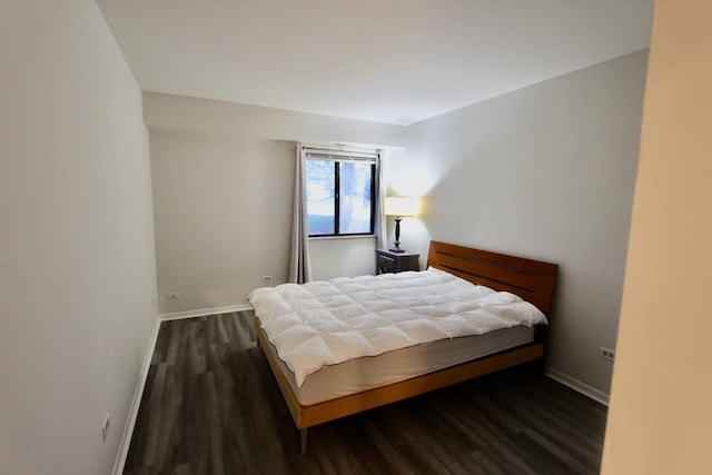 bedroom with wood finished floors and baseboards