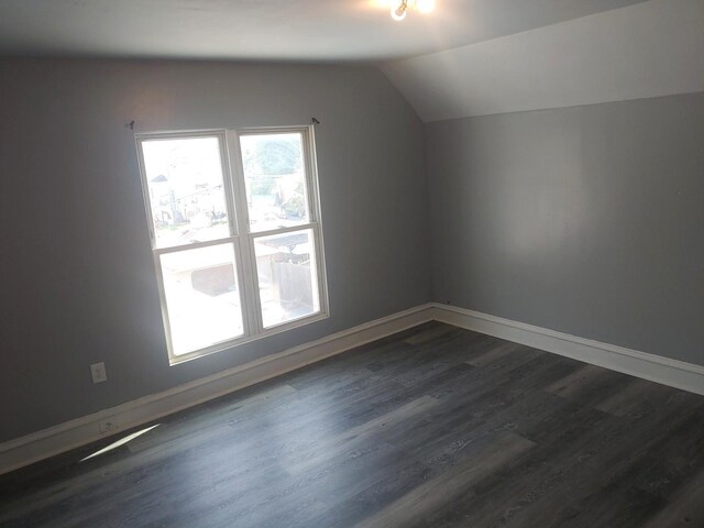 bonus room featuring dark wood finished floors, lofted ceiling, and baseboards