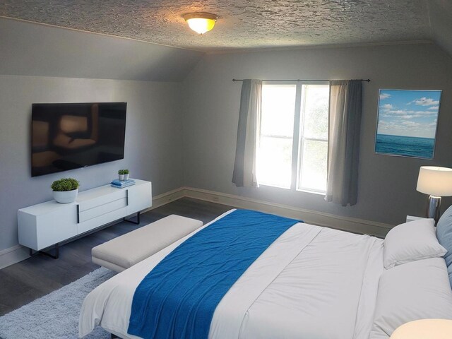 bedroom featuring lofted ceiling, wood finished floors, baseboards, and a textured ceiling