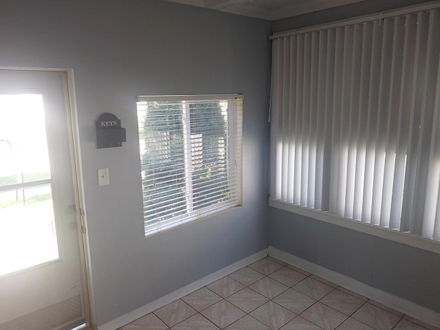 unfurnished room featuring baseboards and light tile patterned floors