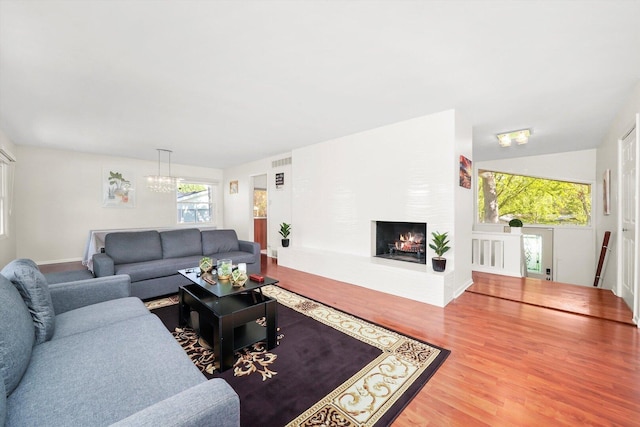 2747 Perry Rd, Flossmoor, IL 60422 - living area featuring wood finished floors, a large fireplace, and a chandelier