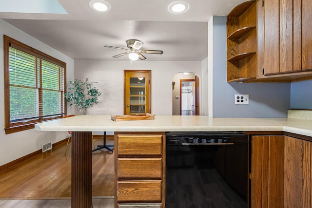 kitchen with black dishwasher, open shelves, brown cabinets, and light countertops
