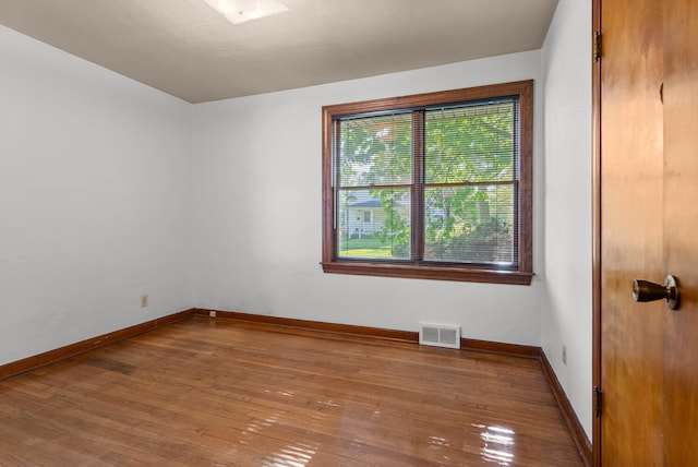 spare room with wood-type flooring and baseboards