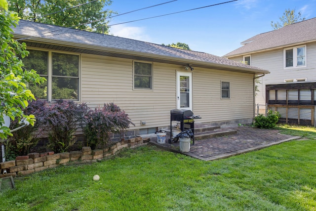 rear view of house featuring a yard and a shingled roof