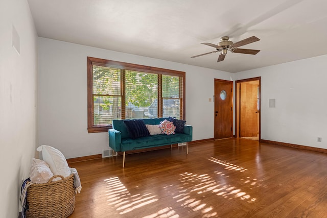 sitting room with wood finished floors, baseboards, and a ceiling fan