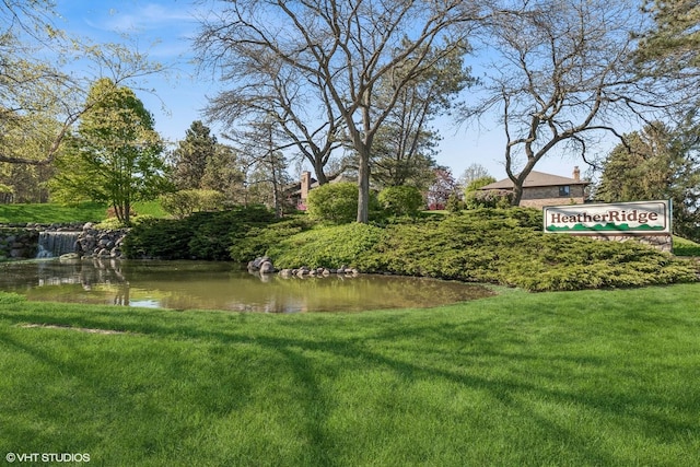 view of home's community with a lawn and a water view