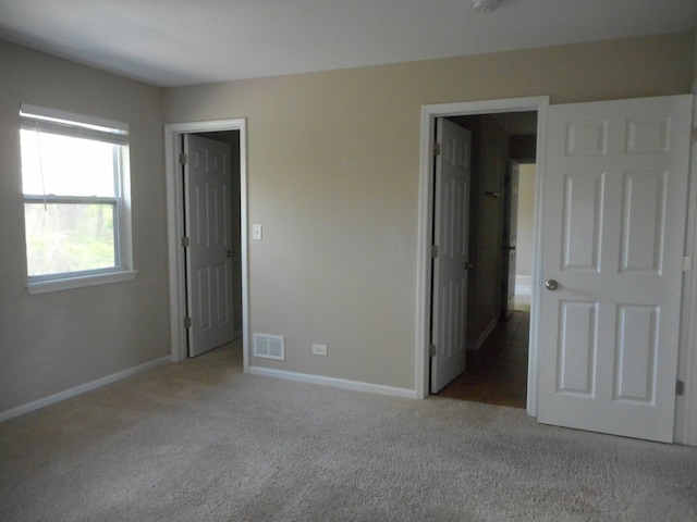 unfurnished bedroom featuring carpet flooring and baseboards