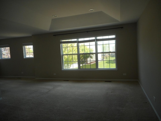 carpeted spare room featuring a raised ceiling, baseboards, and recessed lighting
