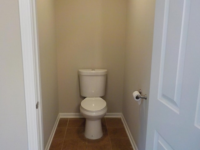 bathroom with toilet, tile patterned flooring, and baseboards