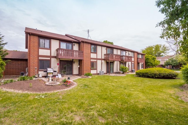 430 Brandy Dr Unit C, Crystal Lake, IL 60014 - rear view of house featuring a yard, stucco siding, a patio, a balcony, and brick siding