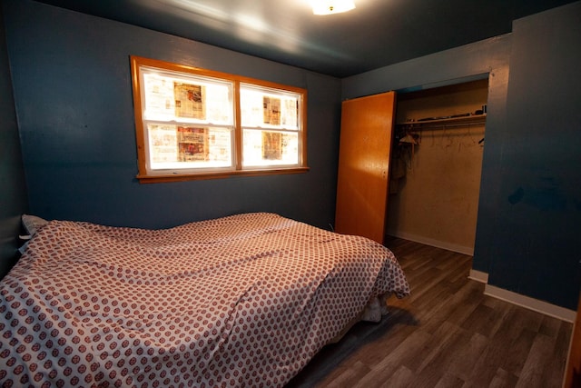 bedroom with a closet, wood finished floors, and baseboards