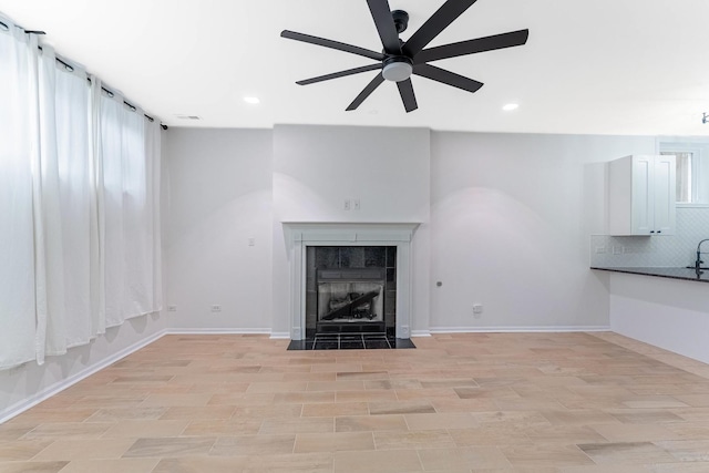 1107 S Independence Blvd Unit 1, Chicago, IL 60624 - unfurnished living room featuring a ceiling fan, recessed lighting, a tiled fireplace, plenty of natural light, and baseboards