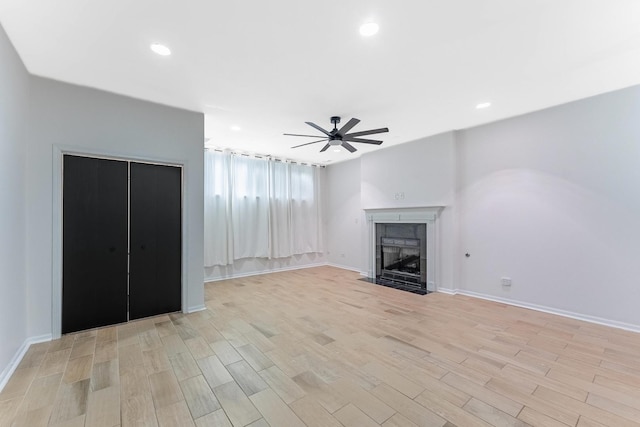 1107 S Independence Blvd Unit 1, Chicago, IL 60624 - unfurnished living room featuring a ceiling fan, light wood-type flooring, a tiled fireplace, baseboards, and recessed lighting