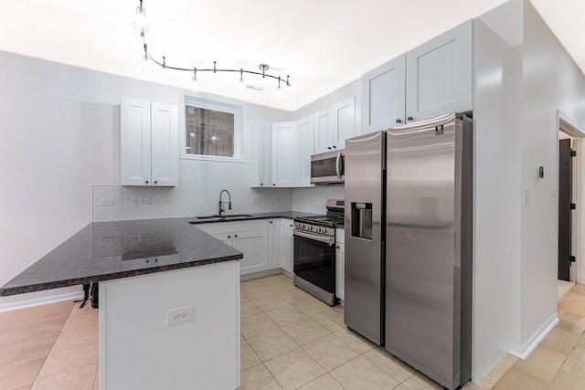 1107 S Independence Blvd Unit 1, Chicago, IL 60624 - kitchen featuring stainless steel appliances, a peninsula, a sink, tasteful backsplash, and dark stone counters