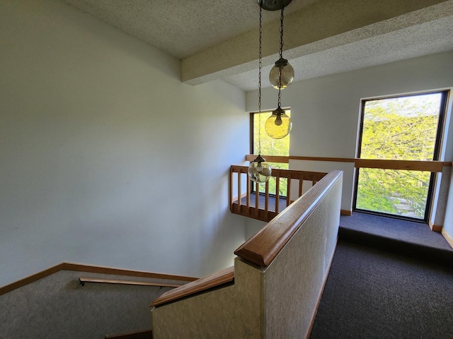 stairway with carpet, baseboards, and a textured ceiling