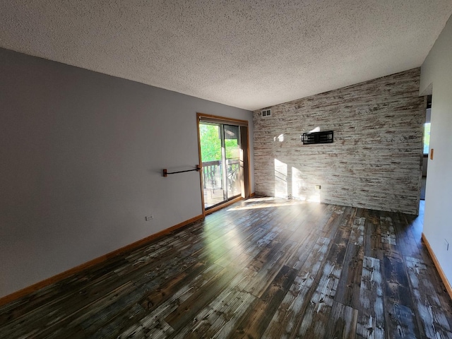 unfurnished living room featuring wood finished floors, a textured ceiling, and baseboards
