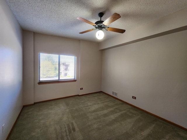 spare room featuring carpet floors, a ceiling fan, a textured ceiling, and baseboards