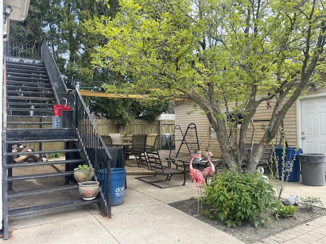 view of patio / terrace with stairs, outdoor dining area, and fence