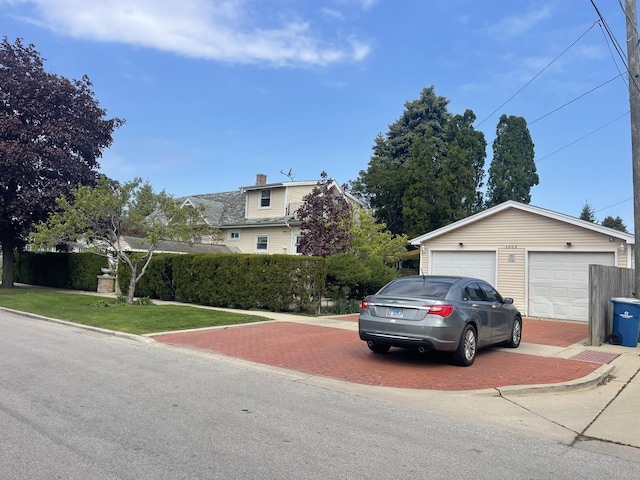 obstructed view of property featuring a garage and an outbuilding
