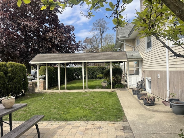 view of green lawn with a patio area
