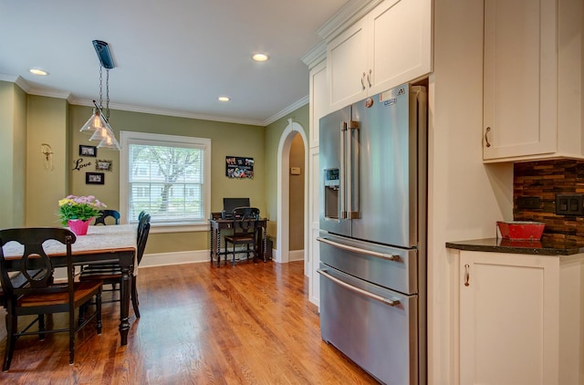 115 S Calumet Ave, Aurora, IL 60506 - kitchen with high end refrigerator, arched walkways, white cabinets, ornamental molding, and light wood-type flooring