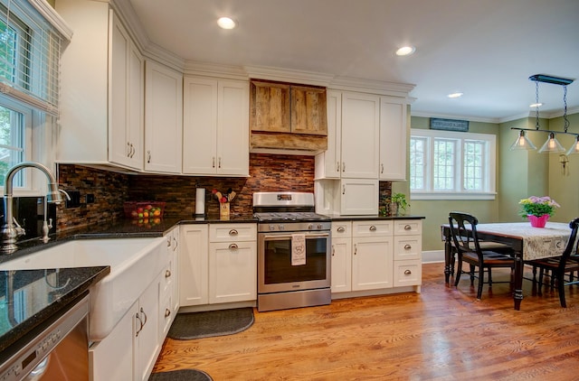 115 S Calumet Ave, Aurora, IL 60506 - kitchen with stainless steel appliances, light wood-style flooring, backsplash, white cabinetry, and ornamental molding