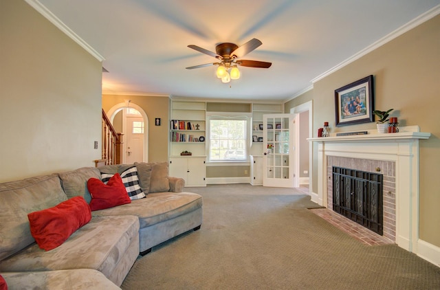 115 S Calumet Ave, Aurora, IL 60506 - carpeted living room featuring crown molding, a brick fireplace, arched walkways, ceiling fan, and stairs