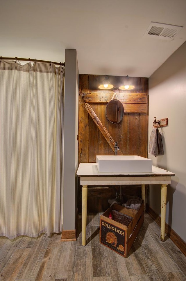 115 S Calumet Ave, Aurora, IL 60506 - bathroom with a sink, wood finished floors, baseboards, and a shower with shower curtain