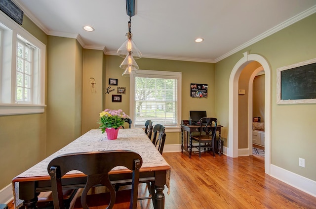 115 S Calumet Ave, Aurora, IL 60506 - dining room featuring healthy amount of natural light, arched walkways, light wood finished floors, ornamental molding, and baseboards
