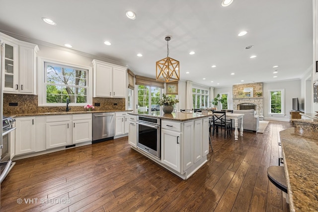 8250 Steepleside Dr, Burr Ridge, IL 60527 - kitchen with stainless steel appliances, ornamental molding, white cabinets, open floor plan, and plenty of natural light