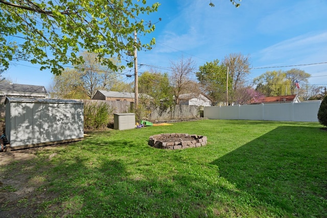 view of yard with a storage unit, an outdoor fire pit, and an outdoor structure