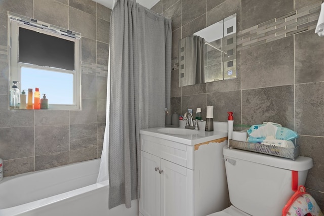 bathroom with tile walls, toilet, shower / tub combo, and vanity