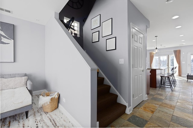 stairs with baseboards, stone tile floors, and recessed lighting