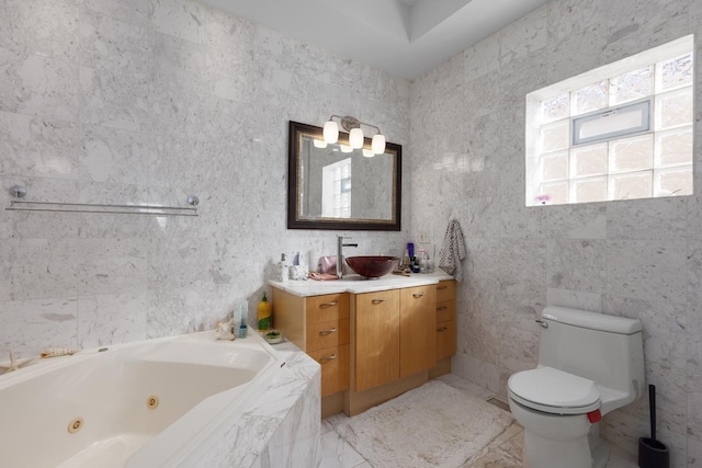 bathroom with toilet, a jetted tub, and vanity