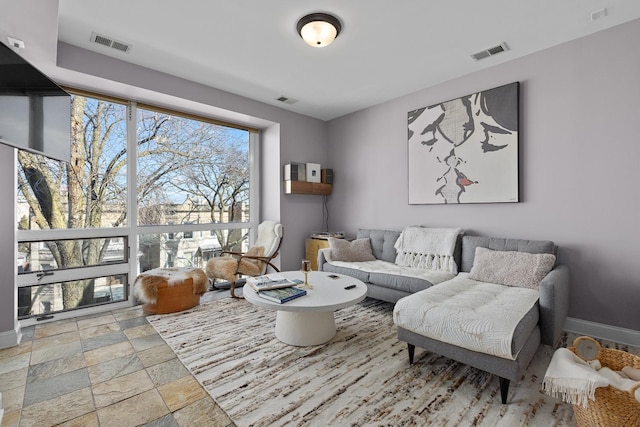 living area with stone tile flooring and baseboards
